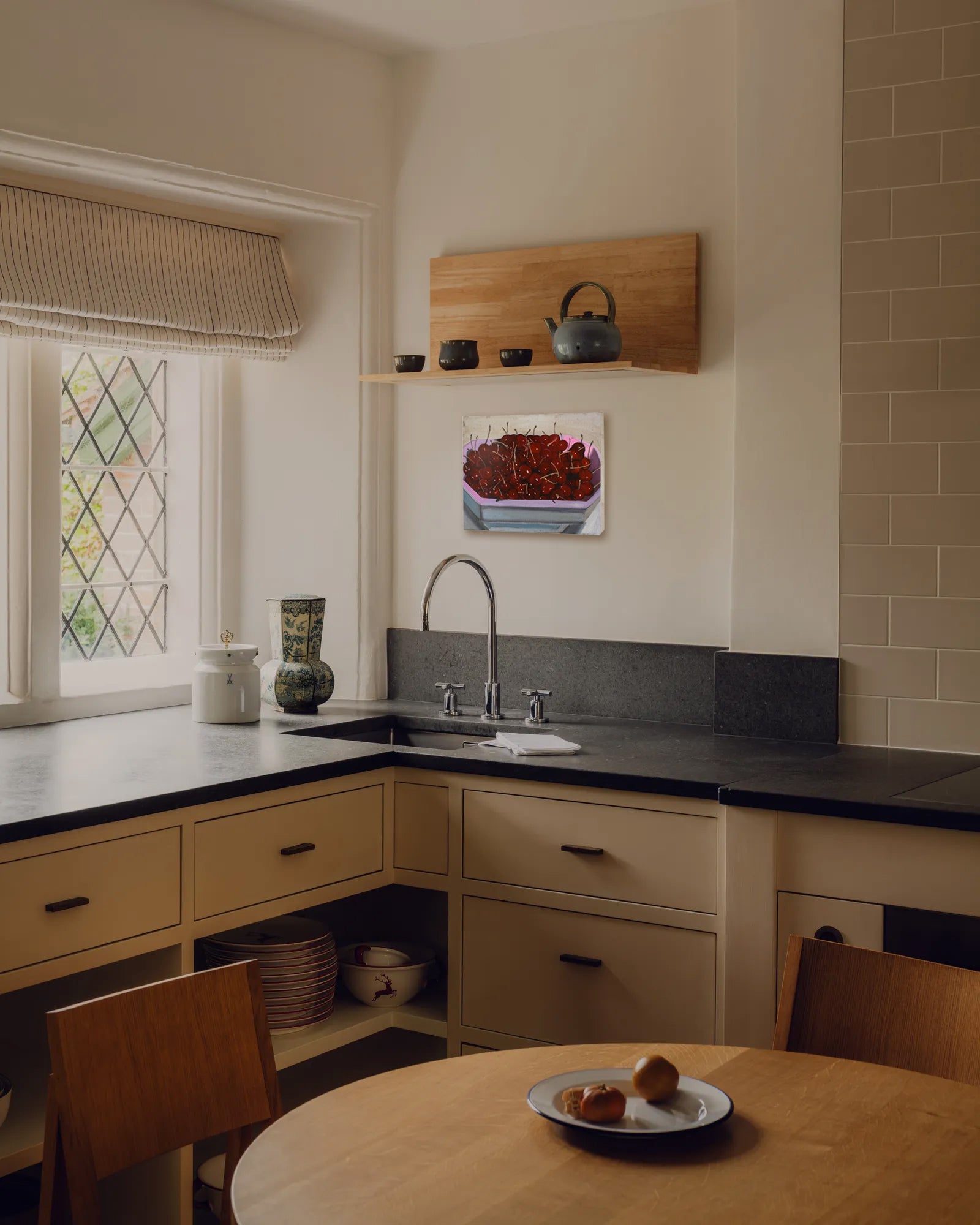 Modern kitchen with black countertops, wooden shelves, and a window with decorative glass.