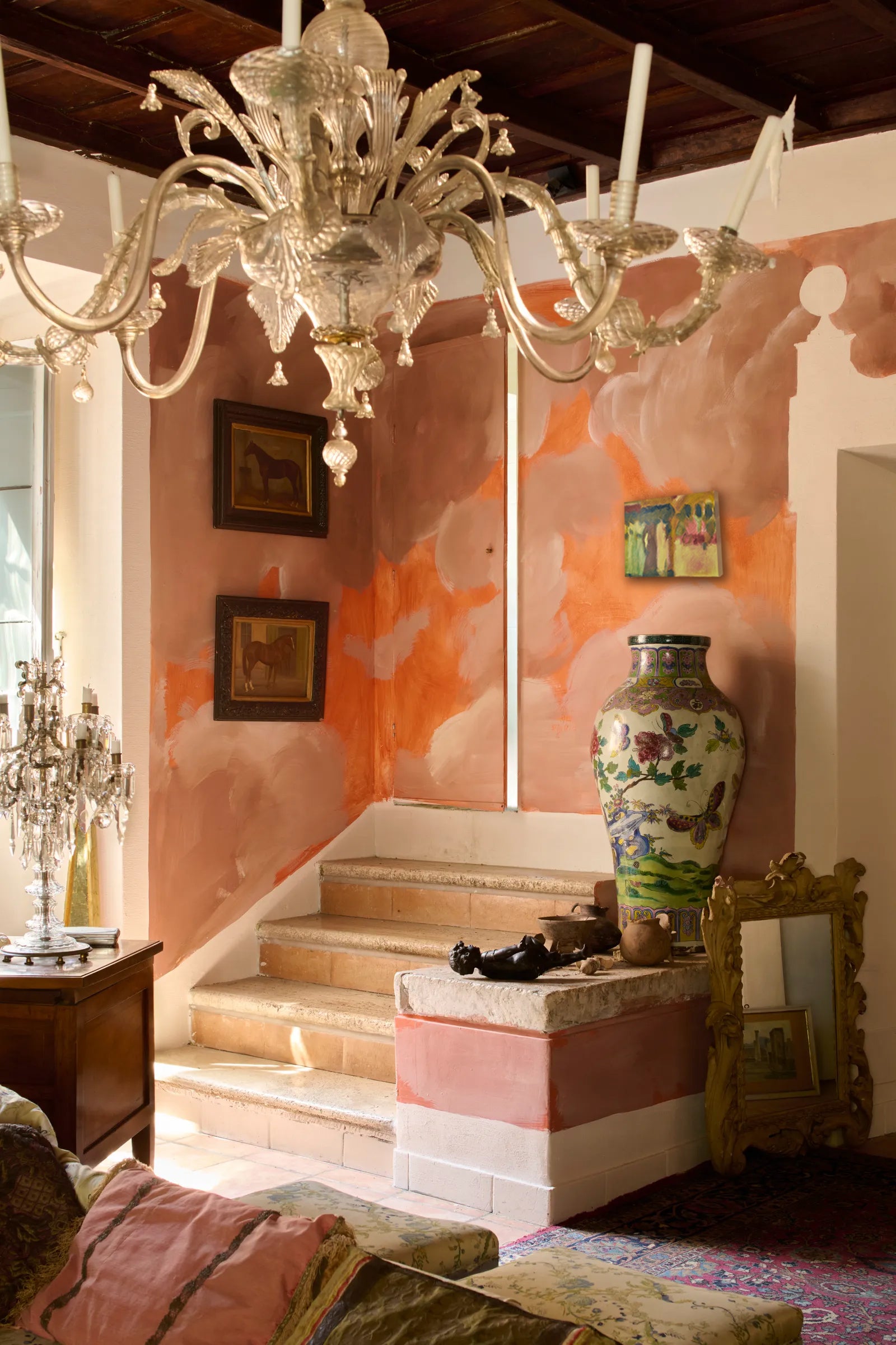 Decorative interior with a chandelier, colorful wall, and decorative items.