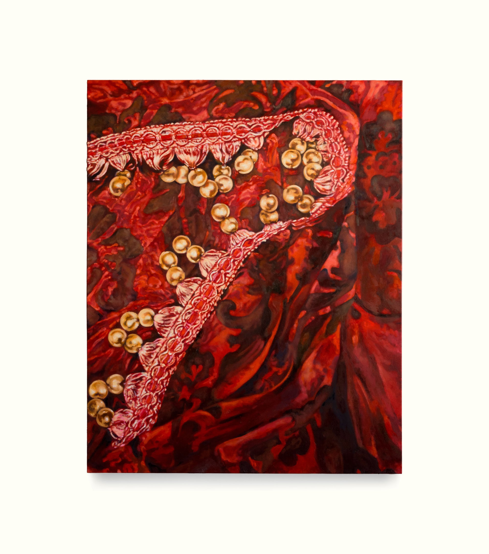 Red fabric with gold embroidery and beads on a white background